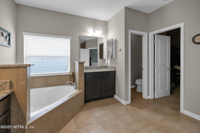 full bathroom featuring vanity, toilet, tile patterned floors, baseboards, and a garden tub