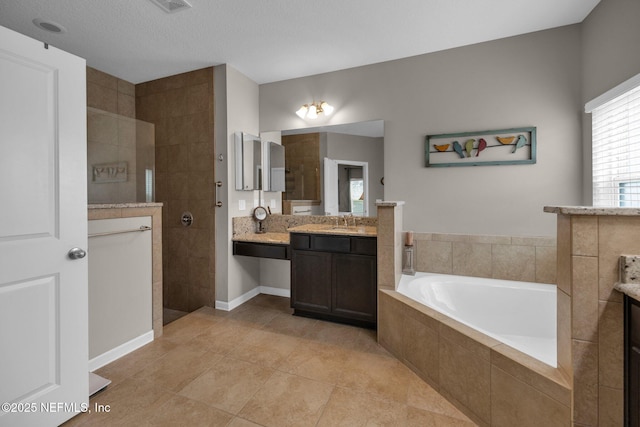 full bathroom featuring a walk in shower, tile patterned flooring, a bath, and vanity