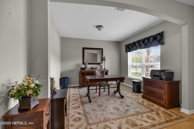 office area featuring baseboards, arched walkways, and visible vents