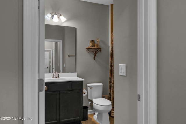 bathroom featuring vanity, toilet, and curtained shower