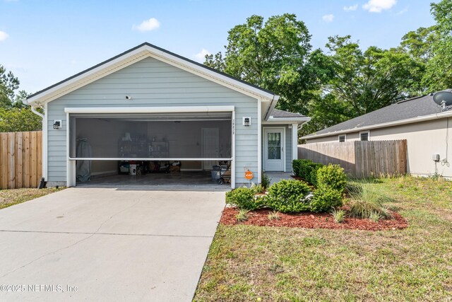 view of front of house featuring fence, a front lawn, and a garage