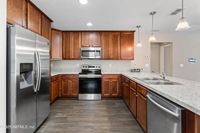 kitchen featuring stainless steel appliances, a sink, dark wood-style floors, visible vents, and a textured ceiling