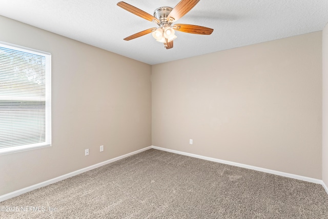 carpeted spare room featuring baseboards, a ceiling fan, and a textured ceiling