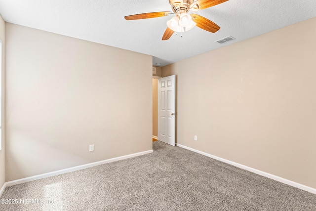 carpeted empty room featuring a ceiling fan, visible vents, and baseboards
