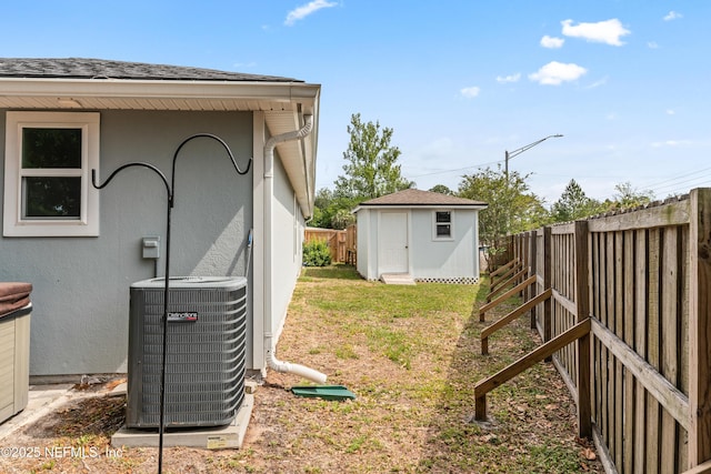 view of yard featuring an outbuilding, a shed, central air condition unit, and a fenced backyard