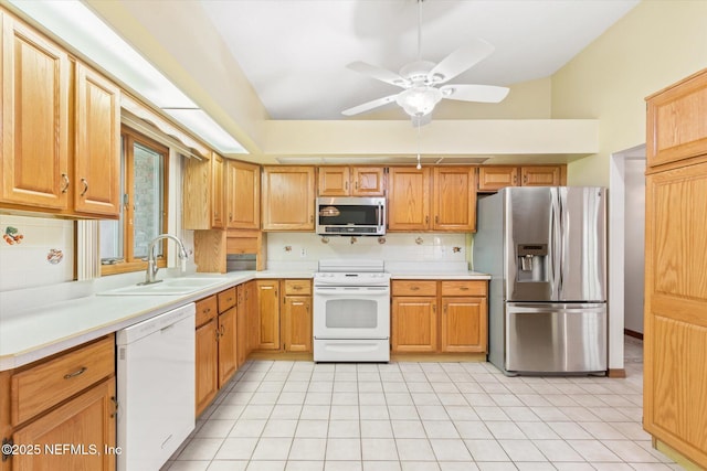 kitchen with tasteful backsplash, a sink, light countertops, appliances with stainless steel finishes, and a ceiling fan