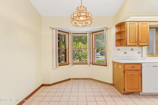 kitchen featuring baseboards, tasteful backsplash, light countertops, and white dishwasher