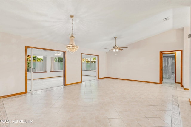 empty room with baseboards, light tile patterned floors, ceiling fan with notable chandelier, and vaulted ceiling