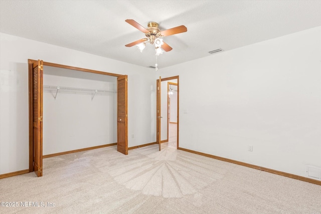 unfurnished bedroom featuring a closet, baseboards, visible vents, ceiling fan, and carpet floors