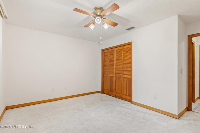 unfurnished bedroom featuring visible vents, baseboards, a closet, and light colored carpet