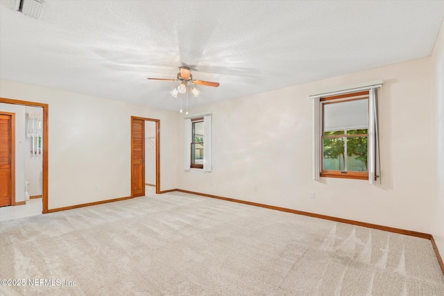 spare room with visible vents, baseboards, ceiling fan, a textured ceiling, and carpet floors