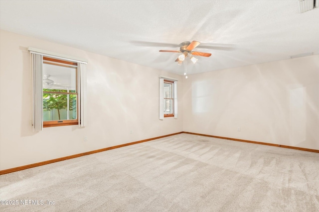 carpeted empty room featuring baseboards, a textured ceiling, and ceiling fan