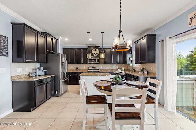 112 Bluffton Ct, Saint Augustine, FL 32092 - kitchen with stainless steel appliances, a center island, a sink, decorative backsplash, and ornamental molding