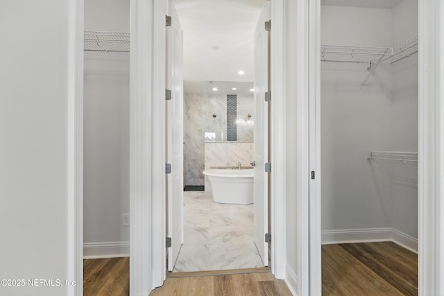 walk in closet with wood finished floors