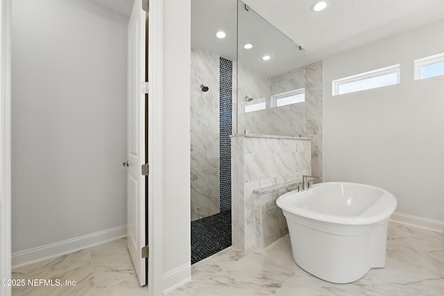 bathroom featuring a freestanding bath, marble finish floor, and walk in shower