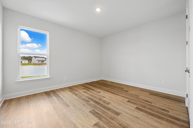 spare room featuring baseboards and wood finished floors