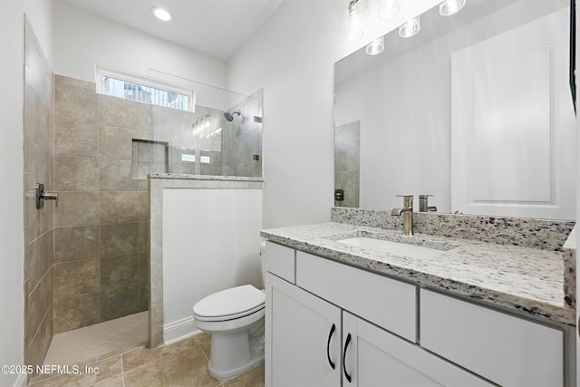 full bath with toilet, a walk in shower, vanity, and tile patterned flooring