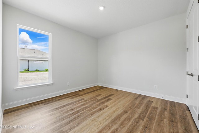 unfurnished room with baseboards and wood finished floors