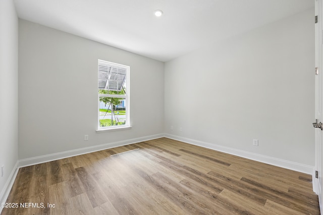 empty room featuring baseboards and wood finished floors
