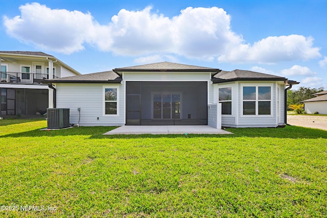 rear view of house featuring a yard, central AC unit, a sunroom, and a patio