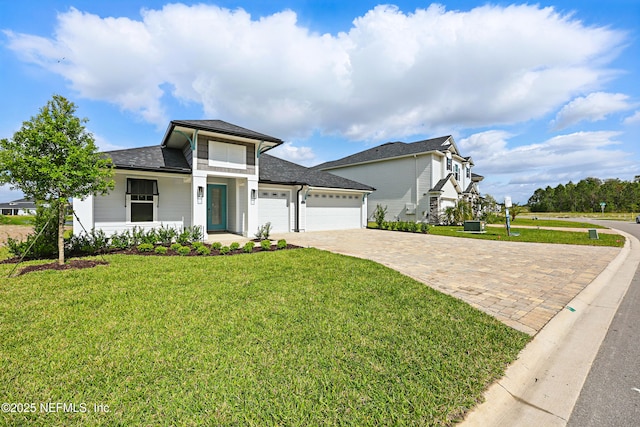 prairie-style house with a front lawn, a garage, and decorative driveway