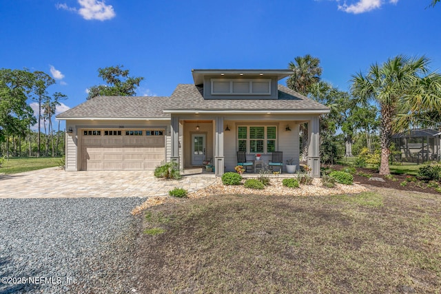 355 Lambert Ave, Flagler Beach, FL 32136 - view of front facade featuring a garage, decorative driveway, a shingled roof, and covered porch