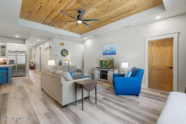 355 Lambert Ave, Flagler Beach, FL 32136 - living area featuring ceiling fan, a tray ceiling, light wood-style flooring, a barn door, and wood ceiling