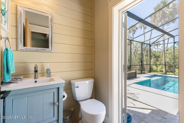 355 Lambert Ave, Flagler Beach, FL 32136 - half bath featuring wood walls, toilet, stone finish floor, and vanity