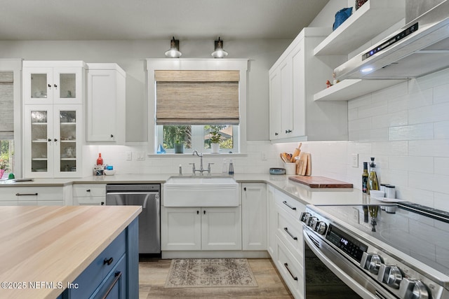 355 Lambert Ave, Flagler Beach, FL 32136 - kitchen featuring a sink, white cabinetry, stainless steel appliances, range hood, and blue cabinets