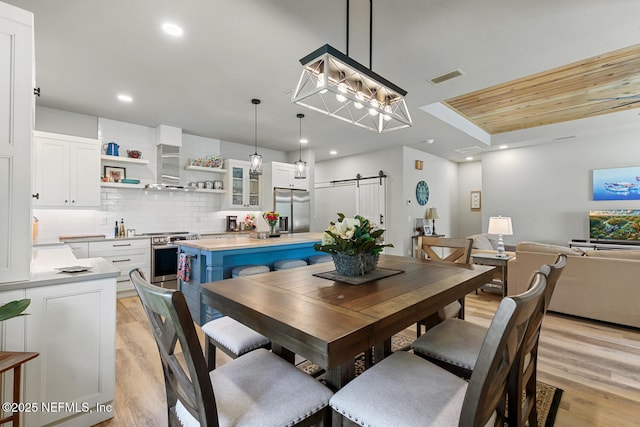 355 Lambert Ave, Flagler Beach, FL 32136 - dining space with light wood-type flooring, recessed lighting, visible vents, and a barn door