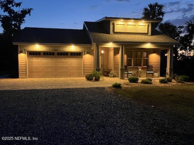 355 Lambert Ave, Flagler Beach, FL 32136 - view of front facade featuring driveway, an attached garage, and covered porch