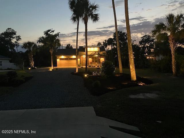 355 Lambert Ave, Flagler Beach, FL 32136 - yard at dusk with driveway and an attached garage