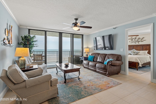 275 1st St S Unit 504, Jacksonville Beach, FL 32250 - living area featuring crown molding, a ceiling fan, a water view, a textured ceiling, and expansive windows