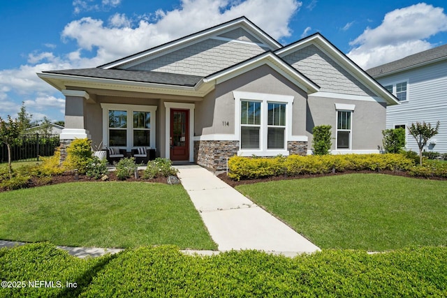 114 Fremont Ave, Saint Augustine, FL 32095 - craftsman-style house with a front lawn, fence, stone siding, and stucco siding
