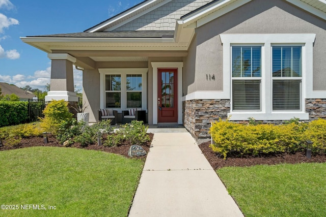 114 Fremont Ave, Saint Augustine, FL 32095 - doorway to property featuring stucco siding, stone siding, and a lawn