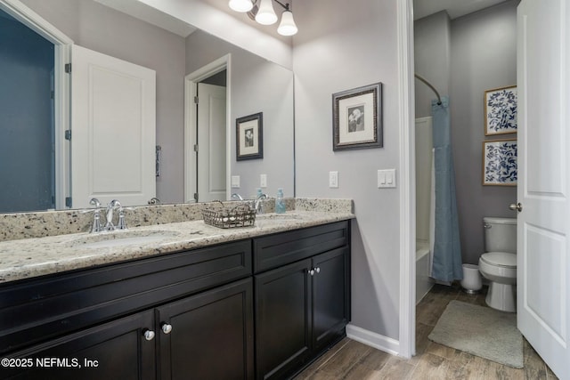 114 Fremont Ave, Saint Augustine, FL 32095 - bathroom with double vanity, a sink, toilet, and wood finished floors