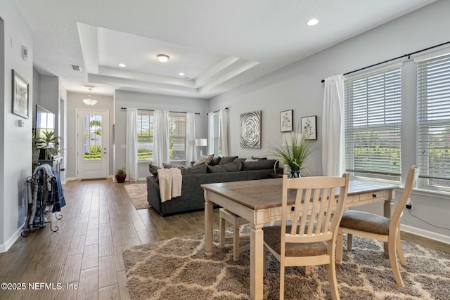 114 Fremont Ave, Saint Augustine, FL 32095 - dining area featuring visible vents, a tray ceiling, baseboards, and wood finished floors