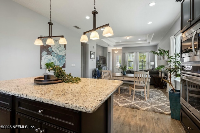 114 Fremont Ave, Saint Augustine, FL 32095 - kitchen featuring visible vents, a raised ceiling, dark wood finished floors, stainless steel appliances, and a kitchen island
