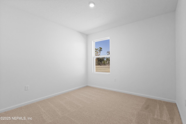 spare room with light colored carpet and baseboards