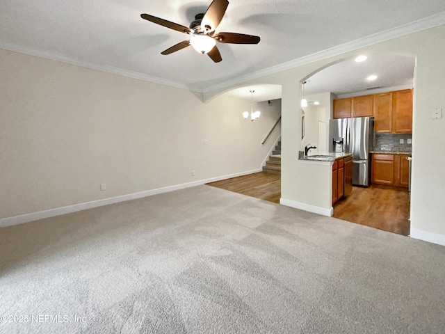 1825 Lago Del Sur Dr, Middleburg, FL 32068 - unfurnished living room featuring crown molding, ceiling fan, arched walkways, and light colored carpet