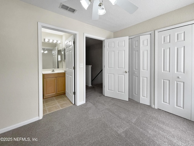 1825 Lago Del Sur Dr, Middleburg, FL 32068 - unfurnished bedroom with two closets, ensuite bathroom, visible vents, light carpet, and a sink