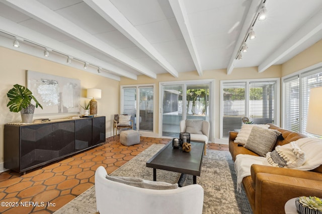 interior space featuring track lighting, baseboards, and beamed ceiling