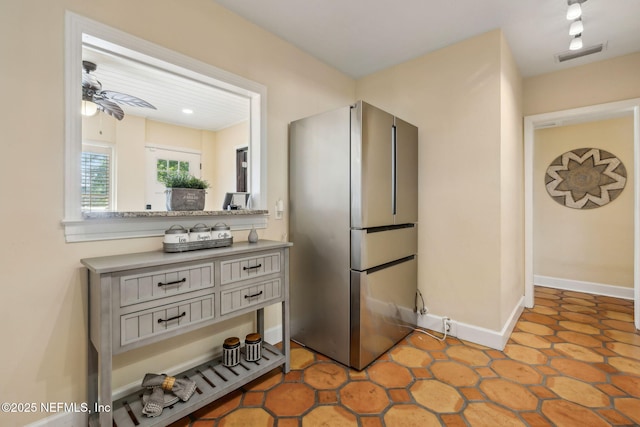 kitchen featuring visible vents, freestanding refrigerator, baseboards, light countertops, and a ceiling fan