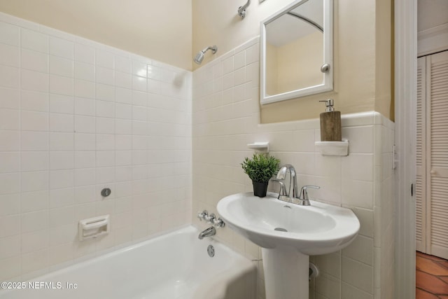 full bathroom featuring wainscoting, tile walls, a closet, and bathtub / shower combination