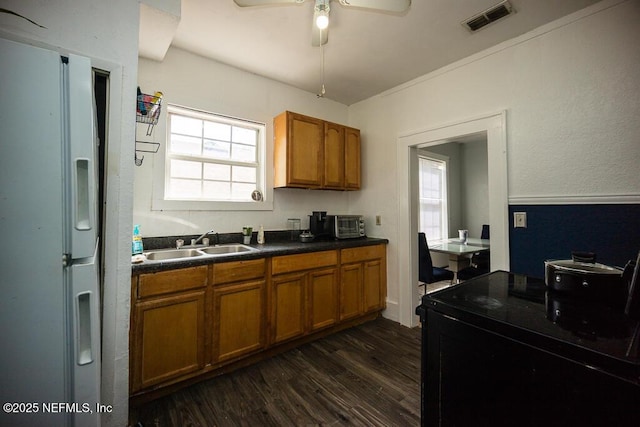 831 Ashford St, Jacksonville, FL 32208 - kitchen featuring freestanding refrigerator, brown cabinets, dark wood finished floors, and dark countertops