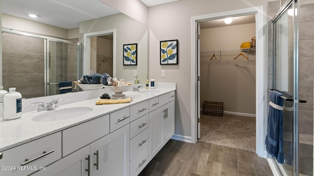 173 Greenwood Dr, Palm Coast, FL 32137 - bathroom featuring a sink, a spacious closet, double vanity, and a stall shower