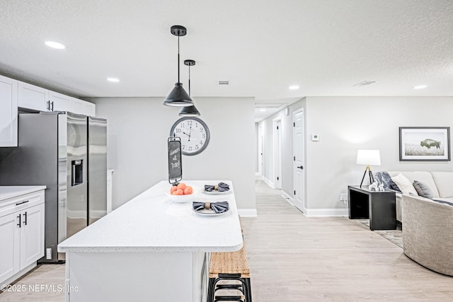 310 Capella Rd, Orange Park, FL 32073 - kitchen with light wood-style floors, stainless steel fridge with ice dispenser, white cabinetry, recessed lighting, and open floor plan