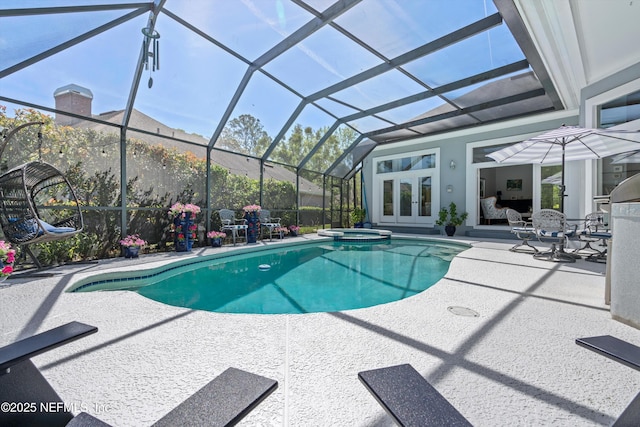 view of pool with a pool with connected hot tub, french doors, a patio, and a lanai