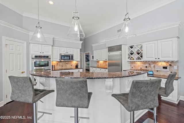 kitchen with white cabinets, stainless steel appliances, and backsplash