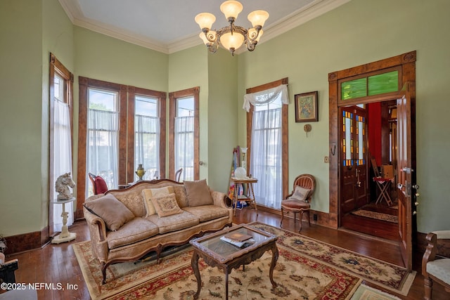 627 Emmett St, Palatka, FL 32177 - living area featuring crown molding, baseboards, hardwood / wood-style floors, and a notable chandelier